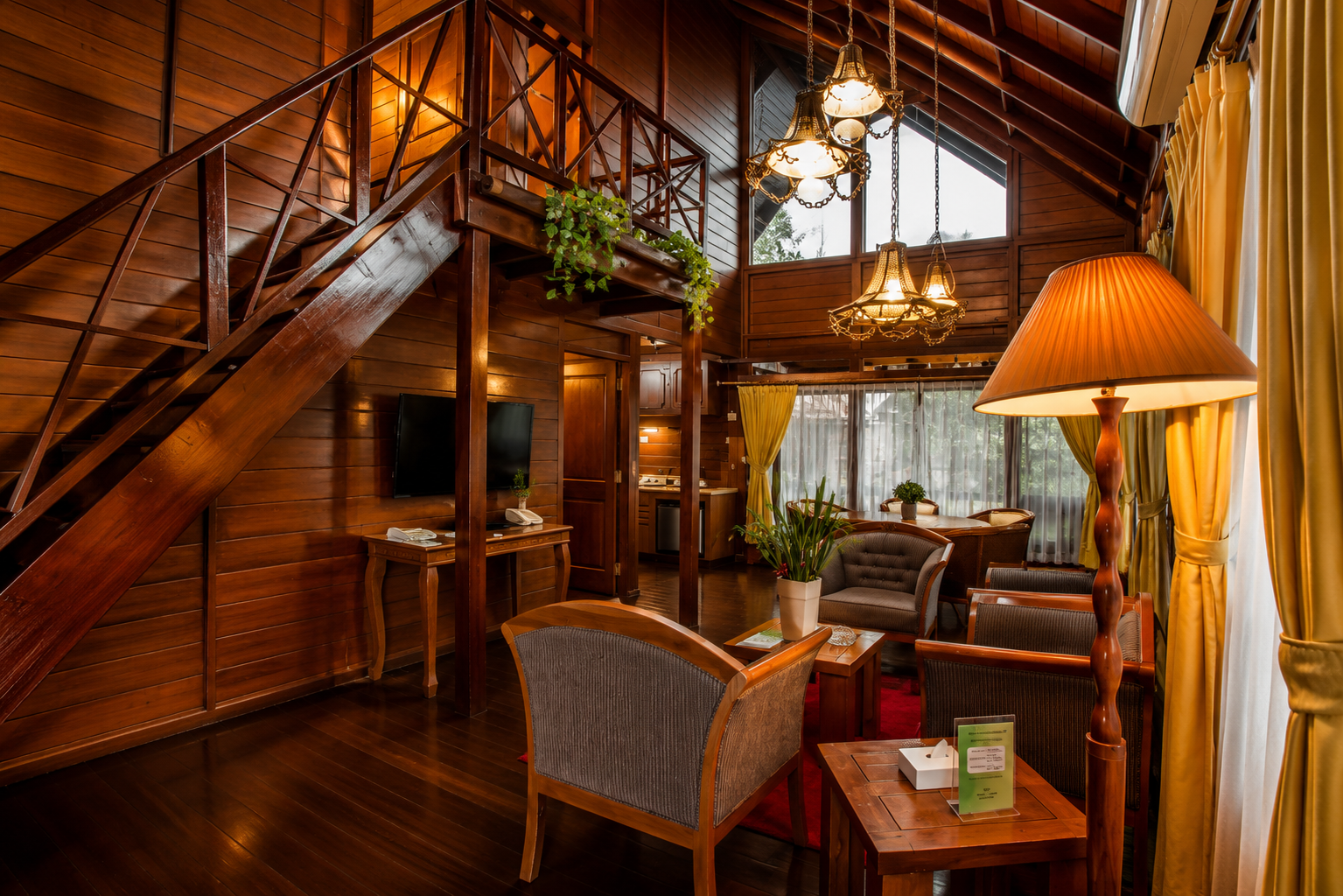 Interior ruang keluarga President Suite di Citra Cikopo Hotel Puncak dengan desain kayu elegan dan suasana resort mewah