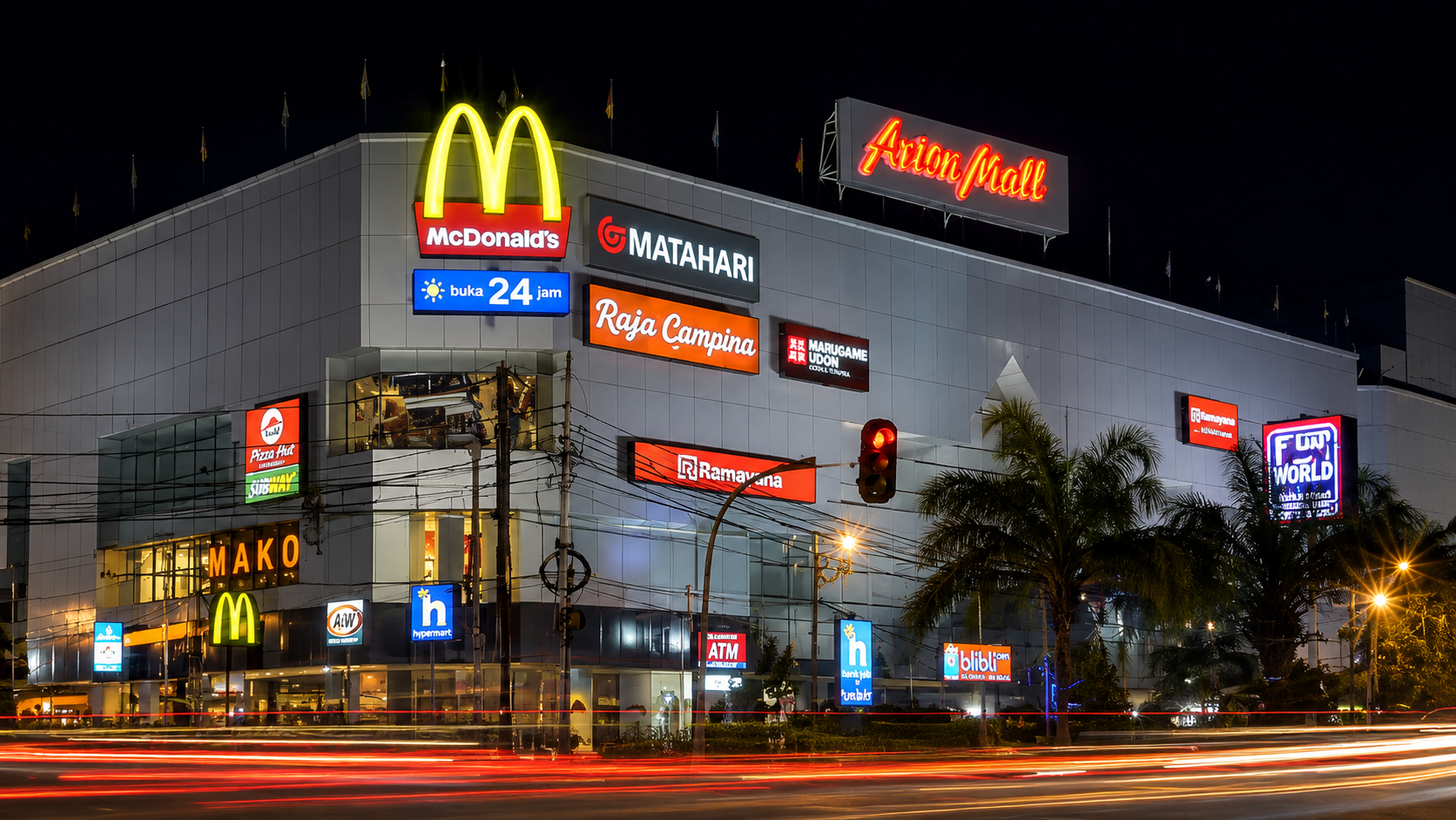 Tampilan eksterior Arion Mall Jakarta pada malam hari dengan pusat perbelanjaan modern dan berbagai tenant retail terkenal